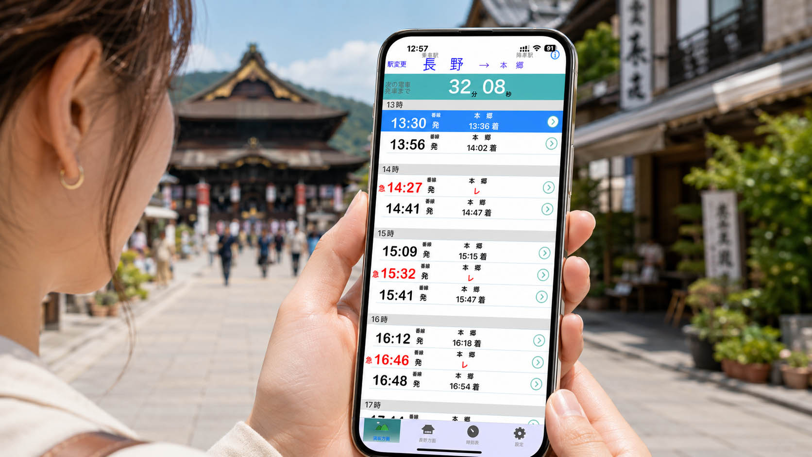 善光寺を背景に、長野電車時刻表を確認している様子